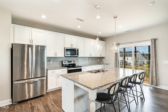 111 Laporte Path, Garner, NC 27529 - kitchen featuring stainless steel appliances, a sink, dark wood finished floors, a center island with sink, and backsplash