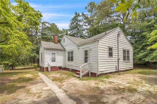 bungalow-style house featuring entry steps, crawl space, a chimney, and a shingled roof