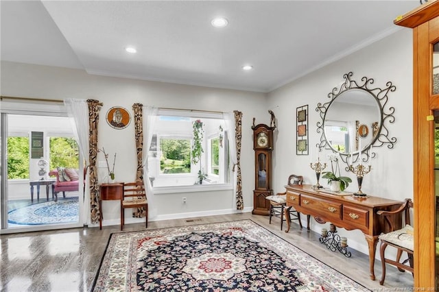 foyer with plenty of natural light, wood finished floors, ornamental molding, recessed lighting, and baseboards