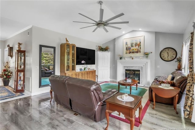 living room featuring ceiling fan, wood finished floors, vaulted ceiling, a high end fireplace, and baseboards