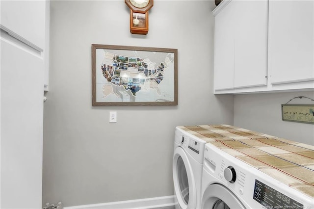 clothes washing area with separate washer and dryer and cabinet space