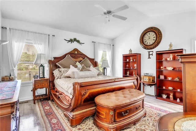 bedroom featuring light wood-style flooring, vaulted ceiling, and ceiling fan