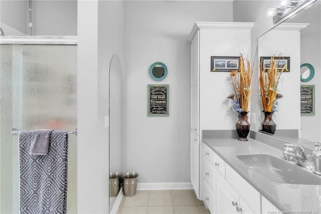 full bathroom with vanity, a shower stall, tile patterned flooring, and baseboards
