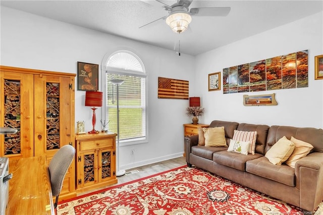 living room featuring ceiling fan, wood finished floors, and baseboards