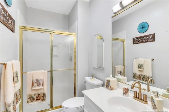 bathroom with toilet, a shower with door, and vanity