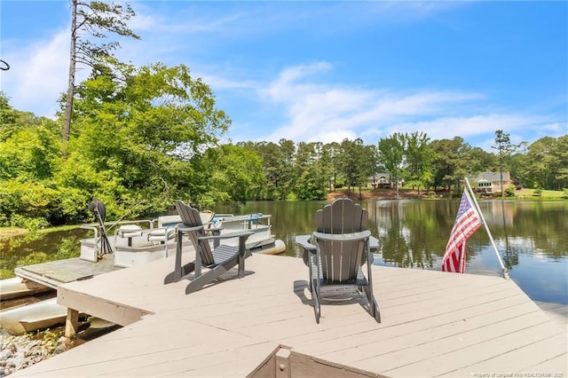 dock area with a water view and view of scattered trees