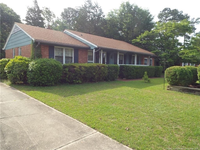 ranch-style home with brick siding and a front yard