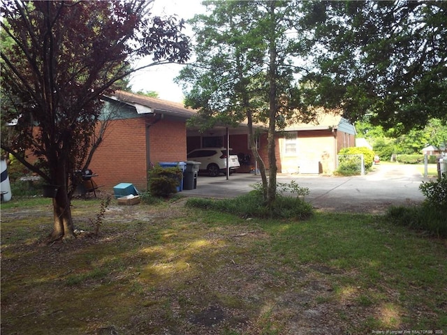 view of home's exterior featuring concrete driveway and brick siding