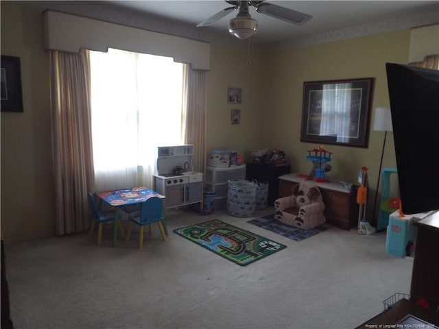 playroom featuring ceiling fan and carpet floors
