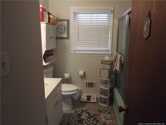bathroom featuring toilet, vanity, baseboards, and enclosed tub / shower combo