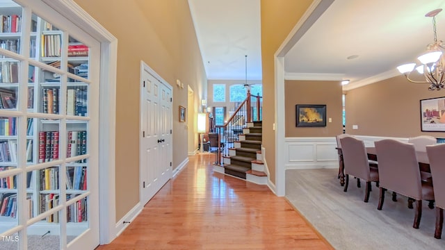 99 Grassy Creek Way, Chapel Hill, NC 27517 - entryway featuring a chandelier, stairway, ornamental molding, light wood-style floors, and a wainscoted wall