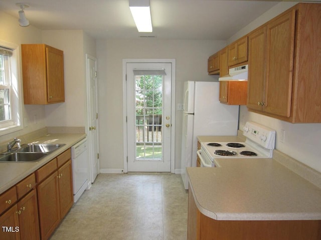 kitchen with under cabinet range hood, white appliances, and brown cabinetry