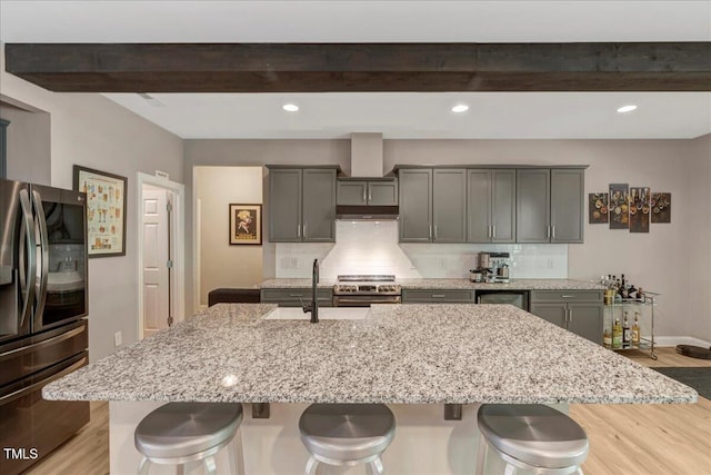 10304 Stallion Way, Bahama, NC 27503 - kitchen featuring stainless steel appliances, beam ceiling, a breakfast bar area, light wood-style floors, and a sink