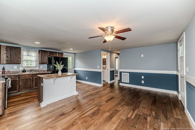 kitchen featuring freestanding refrigerator, a sink, ceiling fan, hardwood / wood-style floors, and recessed lighting