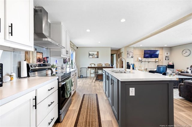 182 Ajax Dr, Saint Pauls, NC 28384 - kitchen with stainless steel appliances, wall chimney range hood, open floor plan, white cabinetry, and light countertops