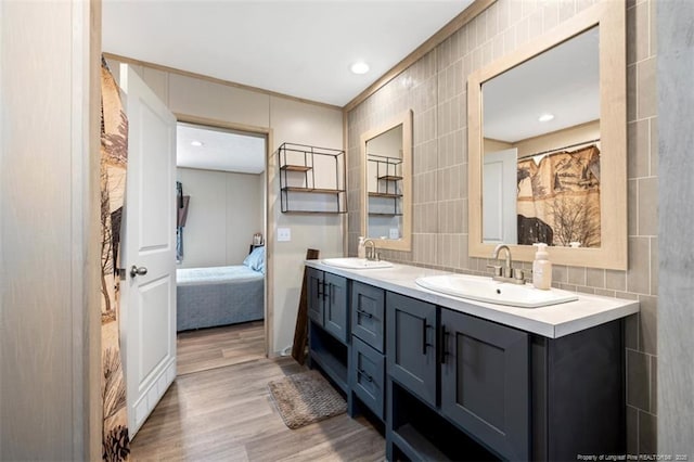 182 Ajax Dr, Saint Pauls, NC 28384 - full bath featuring wood finished floors, double vanity, tile walls, connected bathroom, and crown molding