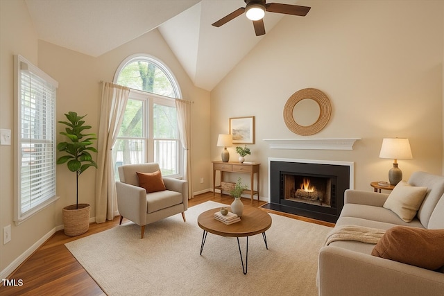4401 Liverpool Ln, Raleigh, NC 27604 - living room with a fireplace with flush hearth, wood finished floors, a ceiling fan, and high vaulted ceiling