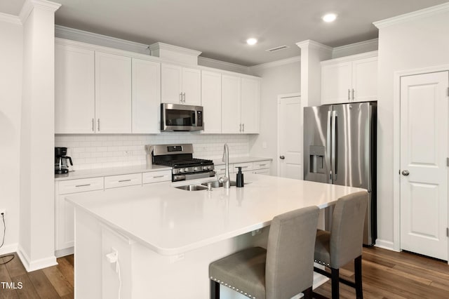 kitchen featuring stainless steel appliances, a sink, dark wood-style floors, decorative backsplash, and crown molding
