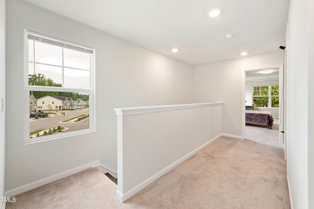 hallway featuring carpet, an upstairs landing, baseboards, and recessed lighting