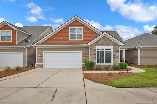 craftsman-style house with stone siding, concrete driveway, and a garage