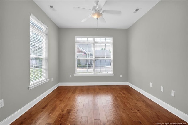 spare room featuring hardwood / wood-style floors, ceiling fan, and baseboards