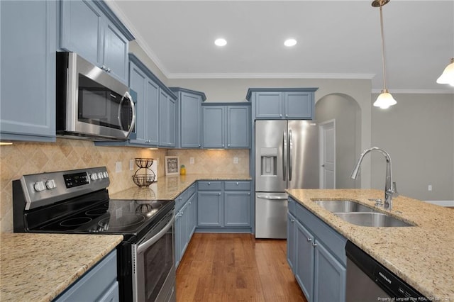 kitchen featuring stainless steel appliances, a sink, blue cabinetry, ornamental molding, and recessed lighting