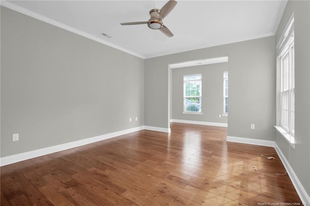 unfurnished room with ceiling fan, hardwood / wood-style flooring, crown molding, and baseboards