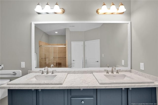 bathroom with a shower stall, double vanity, and toilet