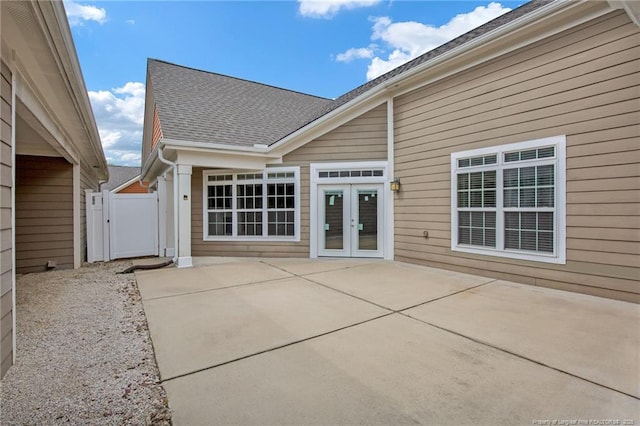 rear view of house with french doors, a patio area, a shingled roof, a gate, and fence