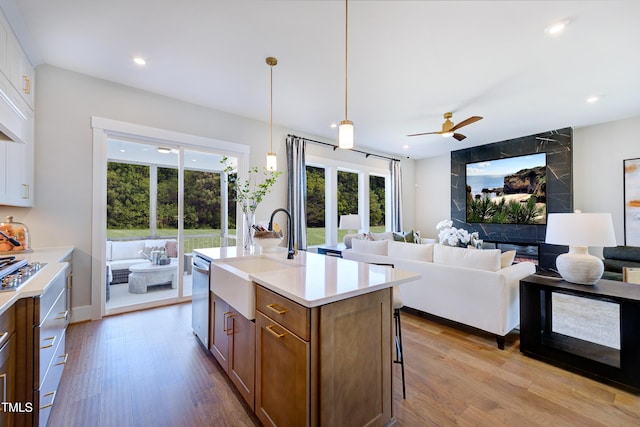 kitchen featuring a sink, wood finished floors, a ceiling fan, open floor plan, and recessed lighting