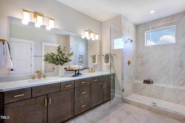 bathroom with a shower stall, double vanity, and marble finish floors