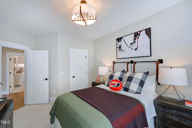 bedroom with a chandelier, baseboards, and light colored carpet