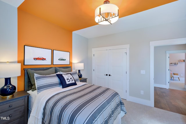 bedroom with a chandelier, carpet floors, a closet, and baseboards