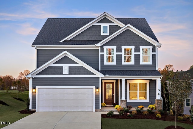 craftsman house with concrete driveway, an attached garage, a porch, roof with shingles, and a yard
