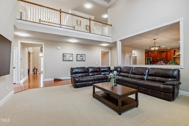 3404 Mount Pisgah Way, Cary, NC 27519 - living room with baseboards, a high ceiling, a chandelier, carpet floors, and wood finished floors