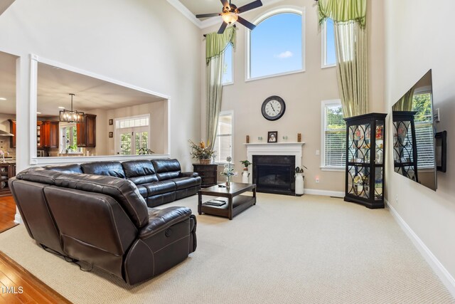 3404 Mount Pisgah Way, Cary, NC 27519 - living area featuring a towering ceiling, baseboards, a fireplace with flush hearth, a ceiling fan, and ornamental molding