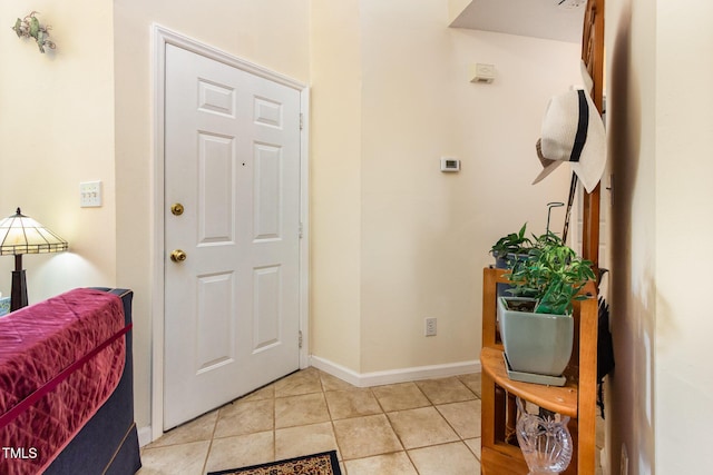 foyer featuring light tile patterned floors and baseboards