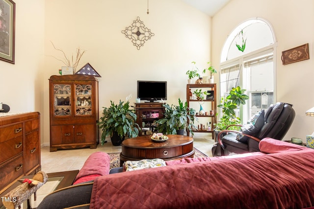 living room with a high ceiling and light tile patterned floors