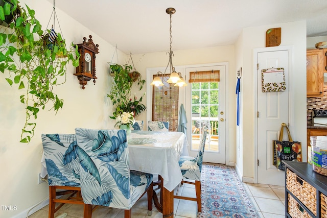dining space featuring a chandelier, light tile patterned flooring, and baseboards