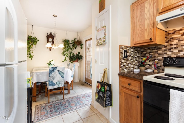 kitchen with freestanding refrigerator, range with electric stovetop, under cabinet range hood, tasteful backsplash, and a chandelier