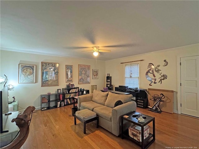 living room with wood finished floors, ceiling fan, and crown molding