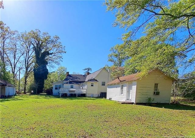 back of house featuring a lawn and an outdoor structure