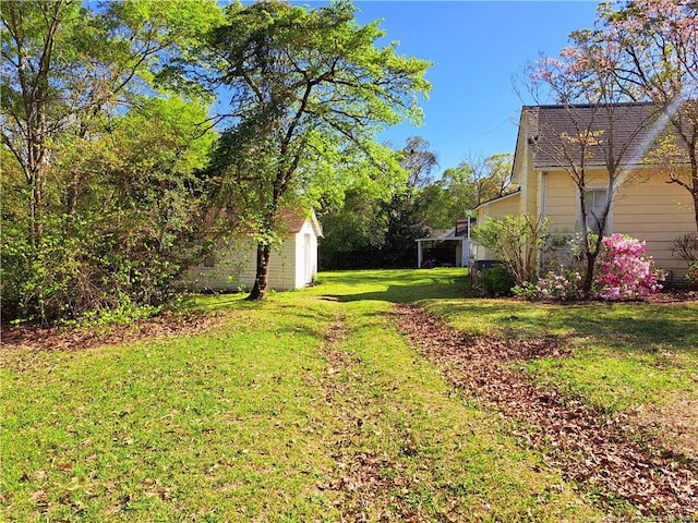 view of grassy yard with a storage shed and an outdoor structure