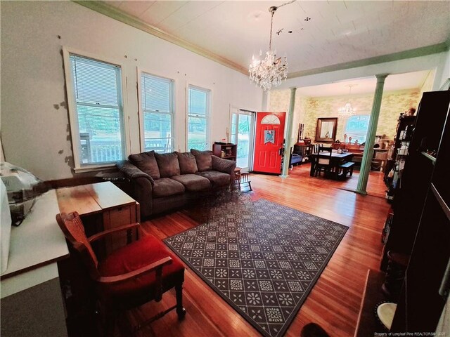 616 N Fulton St, Raeford, NC 28376 - living room featuring a chandelier, ornate columns, healthy amount of natural light, wood finished floors, and crown molding