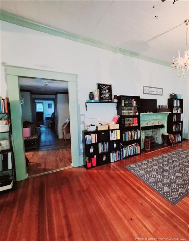 616 N Fulton St, Raeford, NC 28376 - miscellaneous room with a fireplace, wood finished floors, ornamental molding, and a chandelier