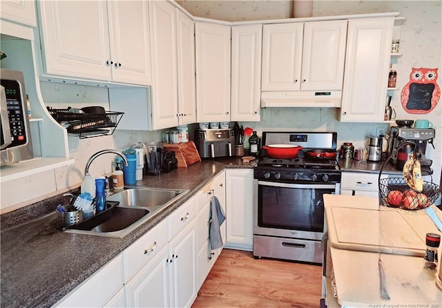 616 N Fulton St, Raeford, NC 28376 - kitchen with stainless steel gas range oven, under cabinet range hood, a sink, and white cabinets