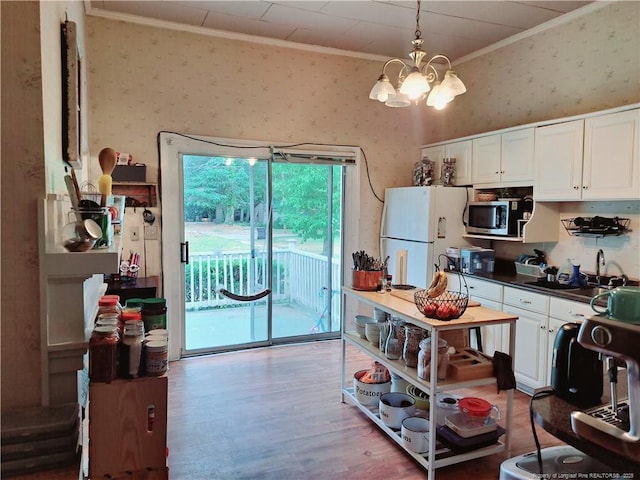 616 N Fulton St, Raeford, NC 28376 - kitchen featuring freestanding refrigerator, ornamental molding, wallpapered walls, stainless steel microwave, and a sink