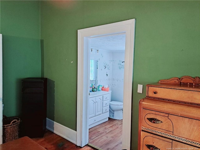 616 N Fulton St, Raeford, NC 28376 - bedroom with wood finished floors, ensuite bath, and baseboards