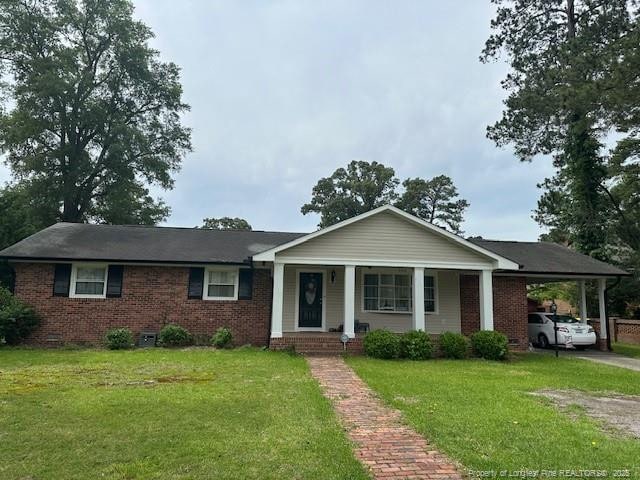 view of front of house featuring brick siding and a front yard