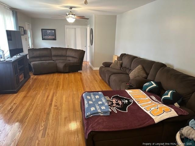 living room with light wood-style floors and a ceiling fan